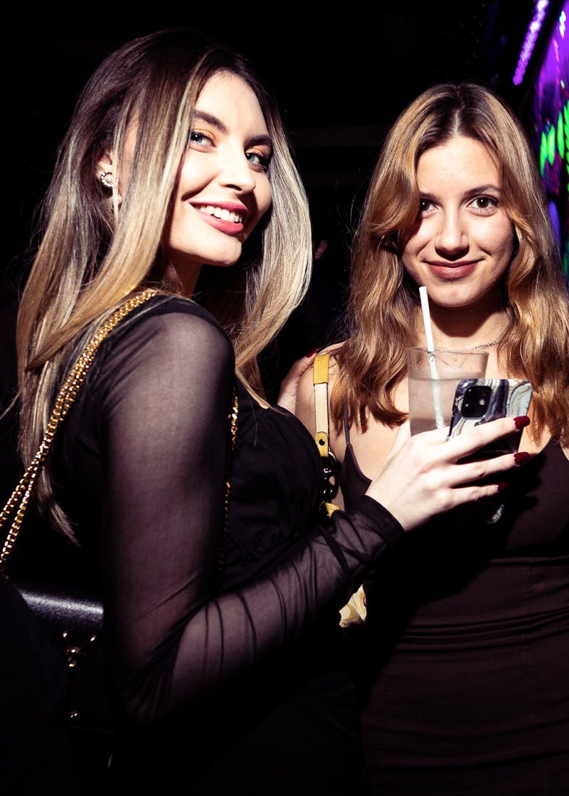 "Two smiling attendees at a vibrant networking event with lively decor in Tonteria."