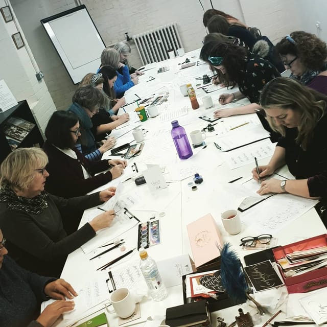 Collaborative workshop at Pen Museum, featuring diverse participants and hands-on activities.