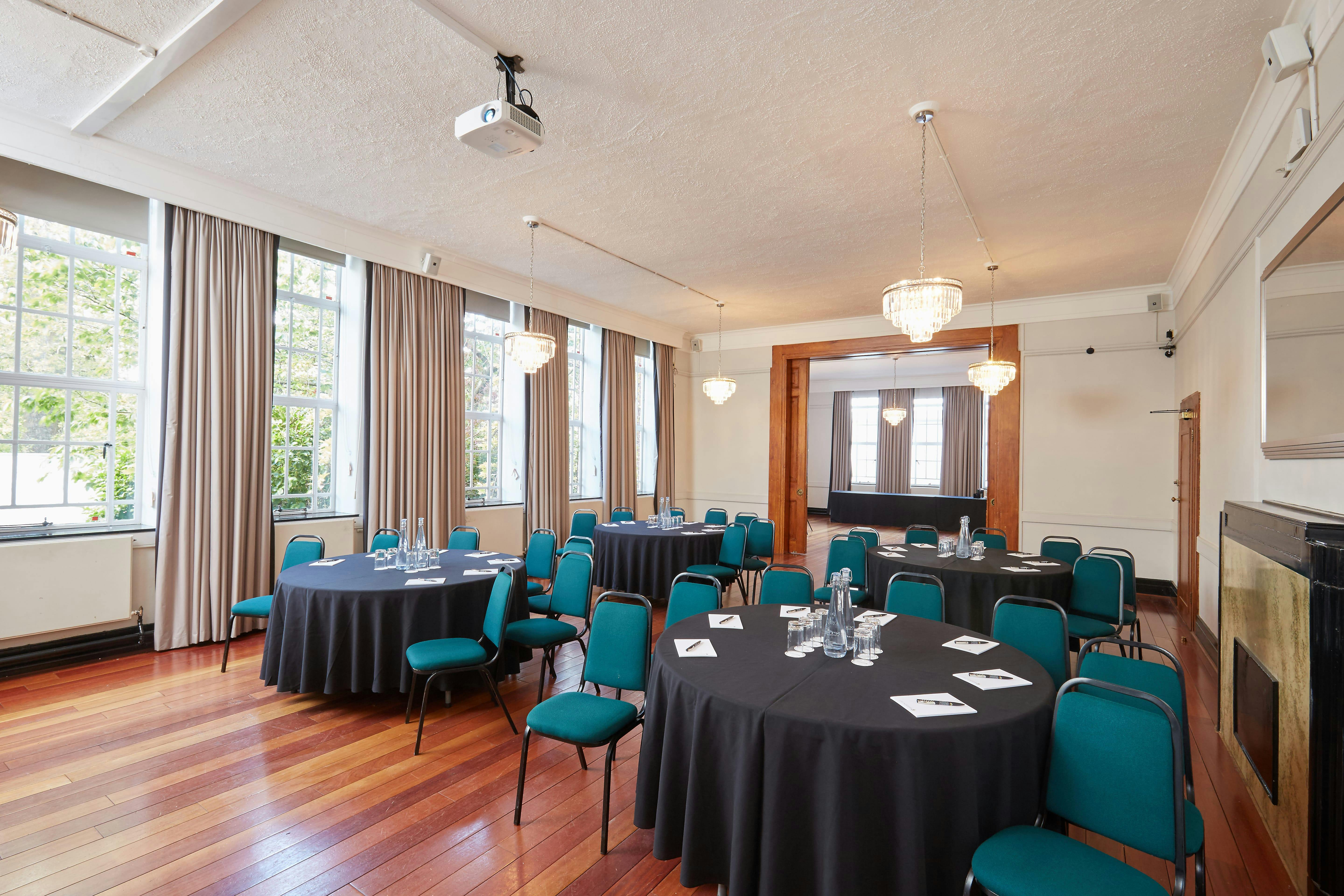 Tuke Common Room with round tables, ideal for corporate meetings and social events.