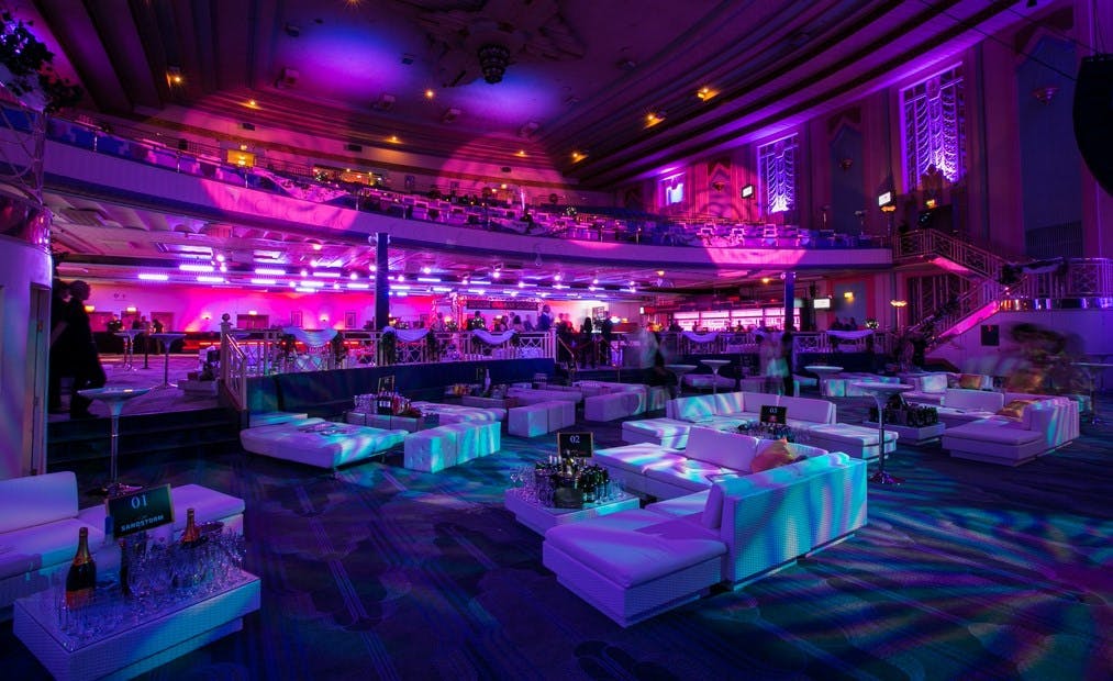 "Vibrant Troxy Christmas party with stylish lounge seating and dynamic lighting."