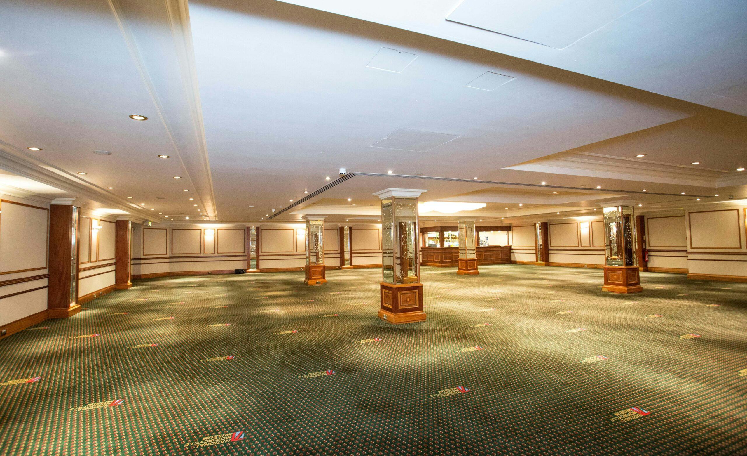 Spacious event venue with elegant pillars, ideal for conferences and banquets.