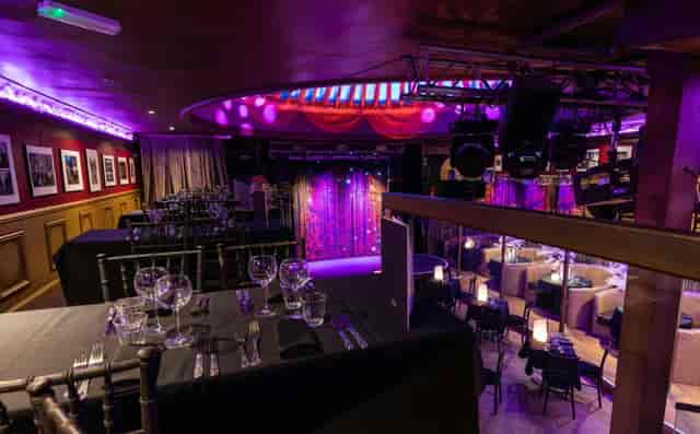 Madam Lola’s Cabaret venue with black-linen dinner setup for corporate events and gala dinners.
