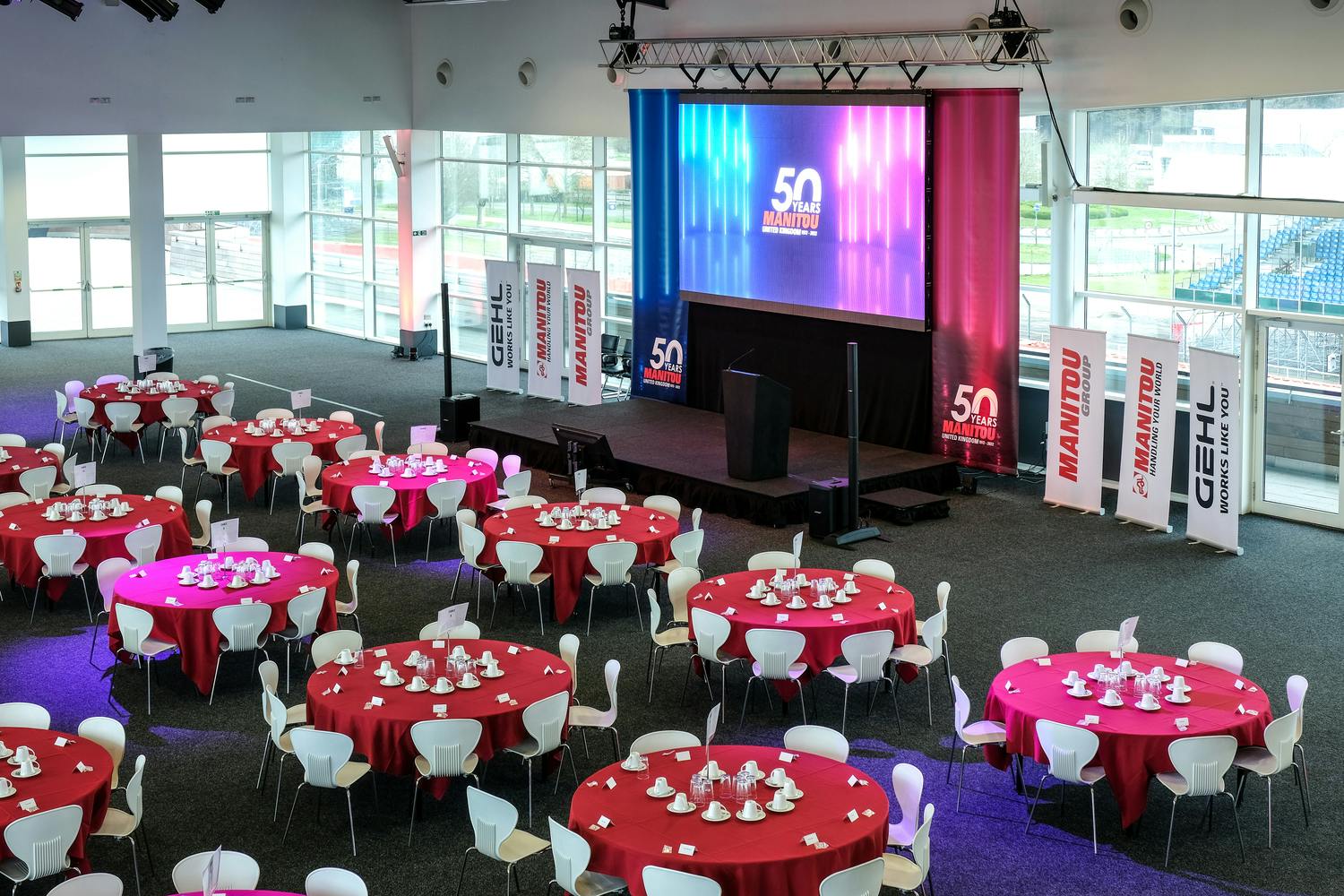 Hall 5 at Silverstone: formal event space with red tables, ideal for conferences and gatherings.