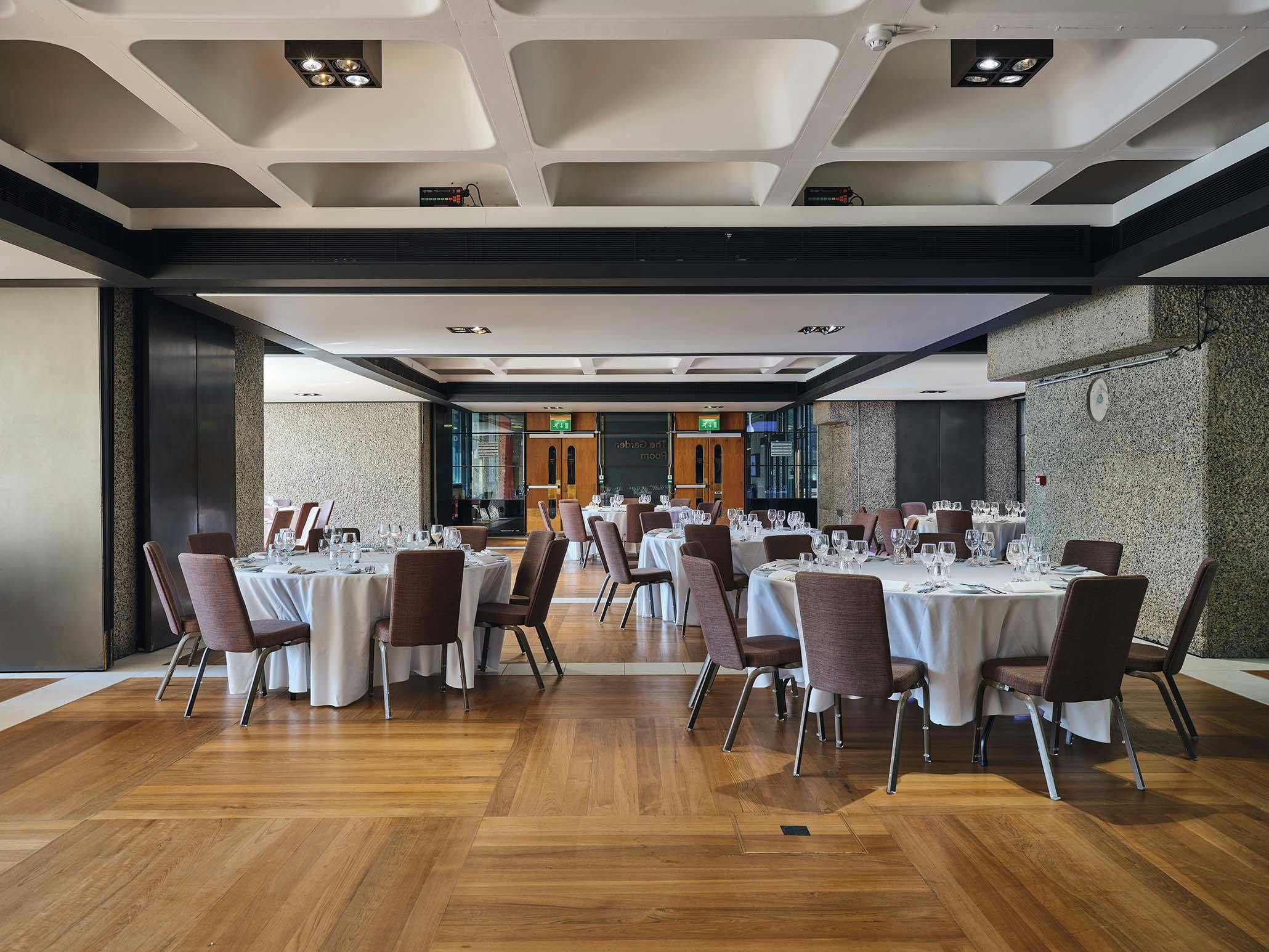 Elegant event space in Barbican Centre with round tables for corporate gatherings.
