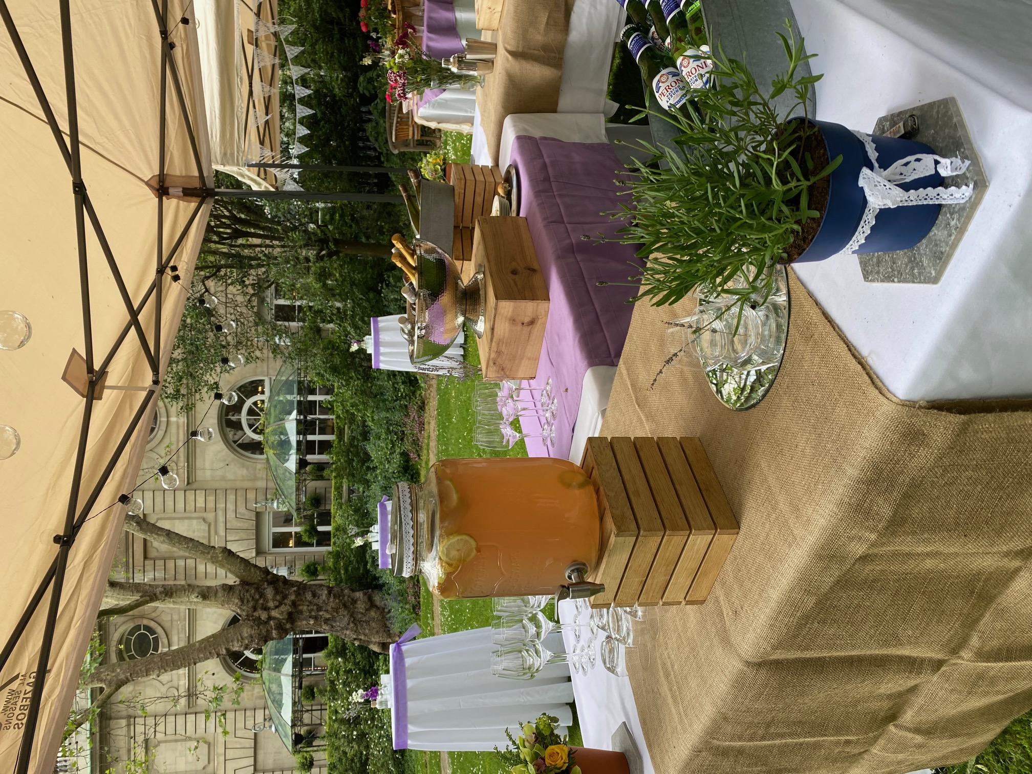Outdoor event setup at Prince Philip House with lemon-infused drink and floral decor. - Banner