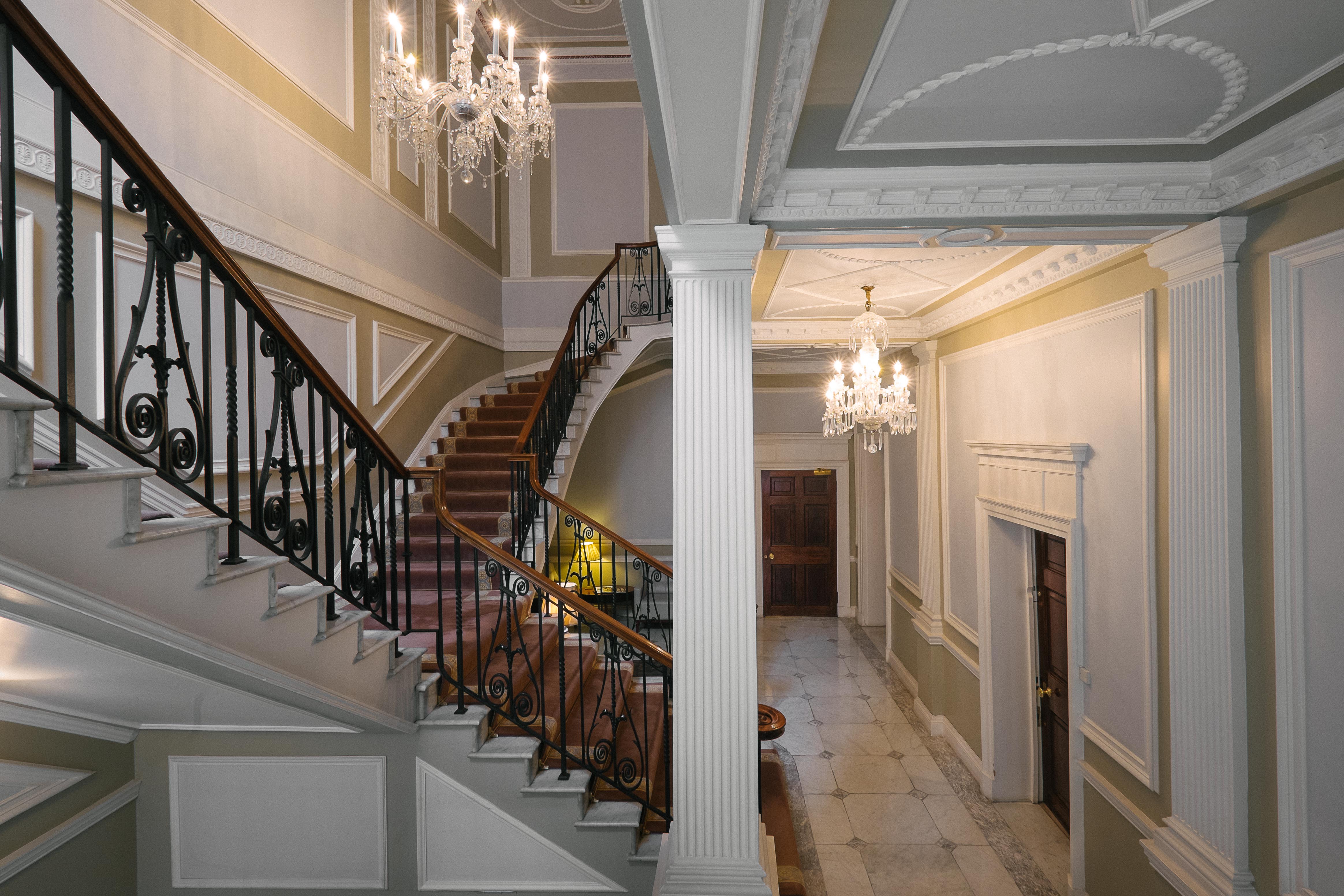 Elegant foyer with grand staircase at Hemingway GreenSpace, ideal for upscale events. - Banner