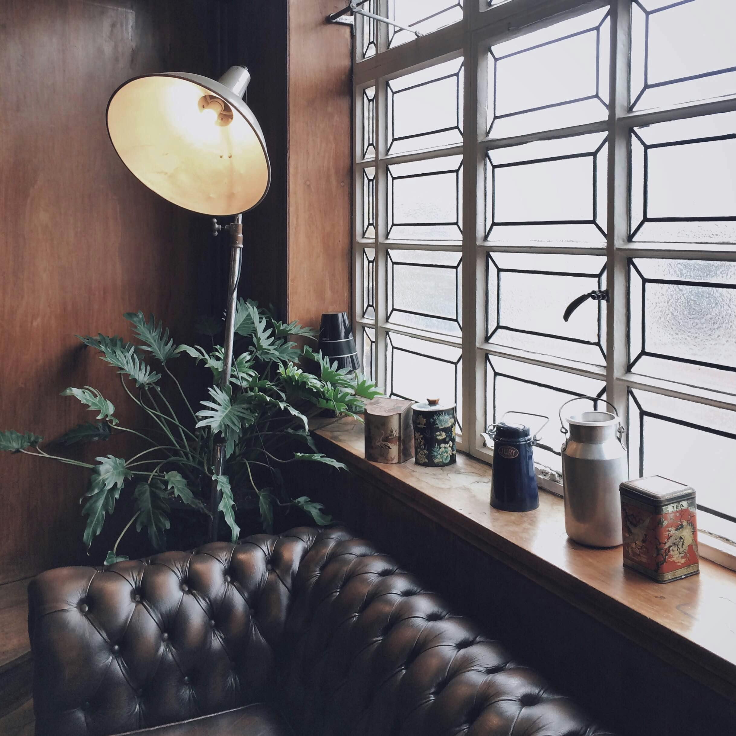 Cozy meeting corner in Town Hall Hotel with vintage decor and greenery for inspiration.