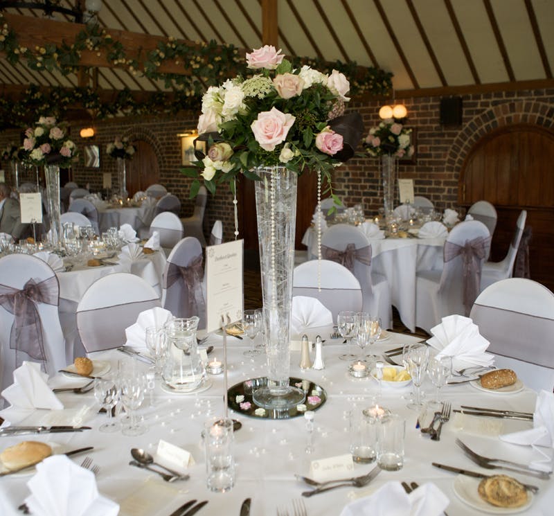 Elegant banquet hall at The Roundels, adorned with floral centerpieces for weddings.