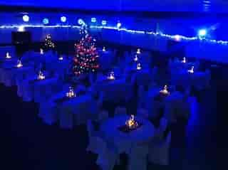 Elegant event space at The Dray, adorned with white linens and festive decor for holiday parties.