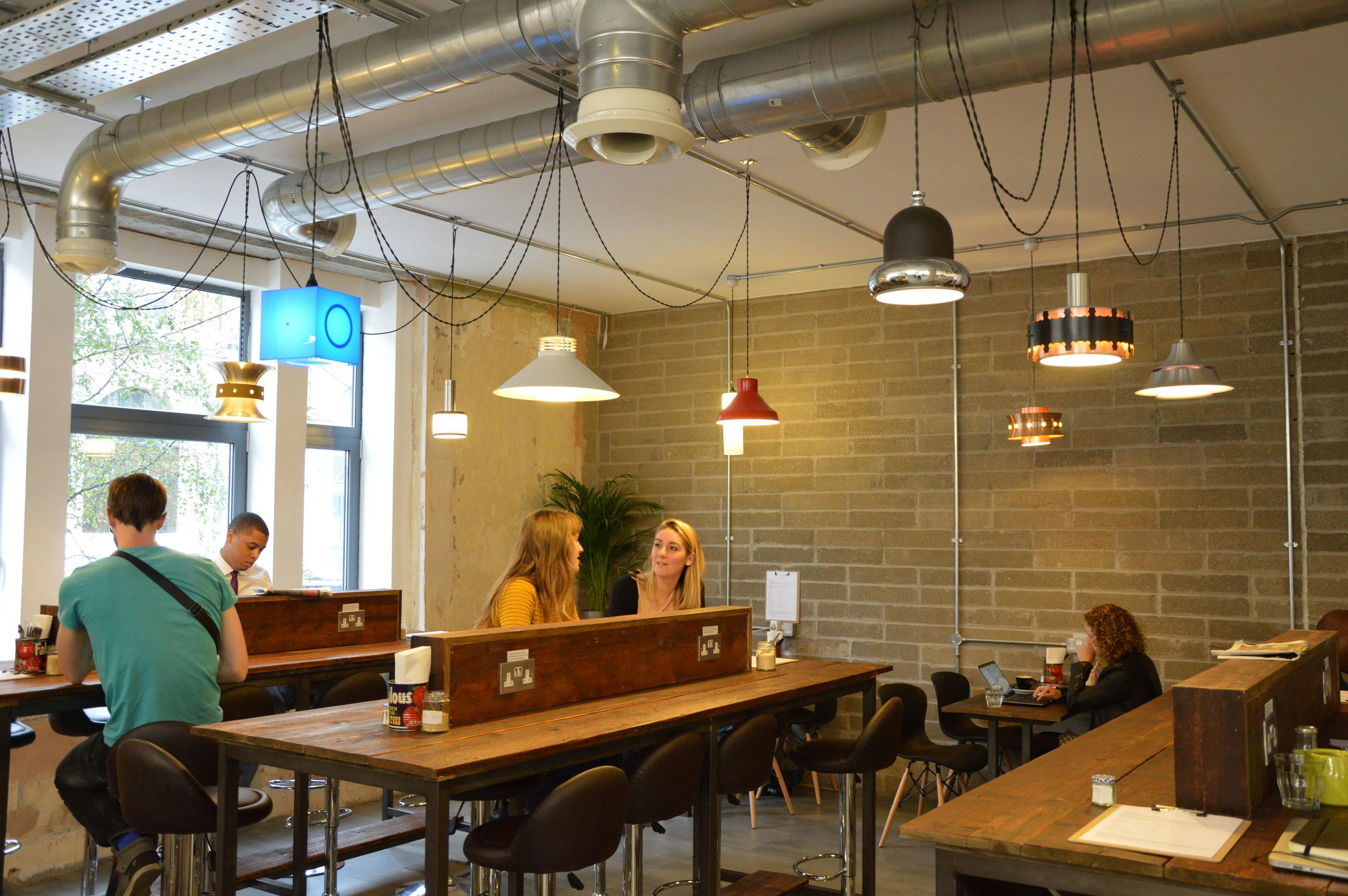 Modern café venue with communal tables, ideal for networking and brainstorming events.