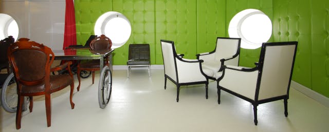 Vibrant meeting space with green walls and circular windows for creative events.