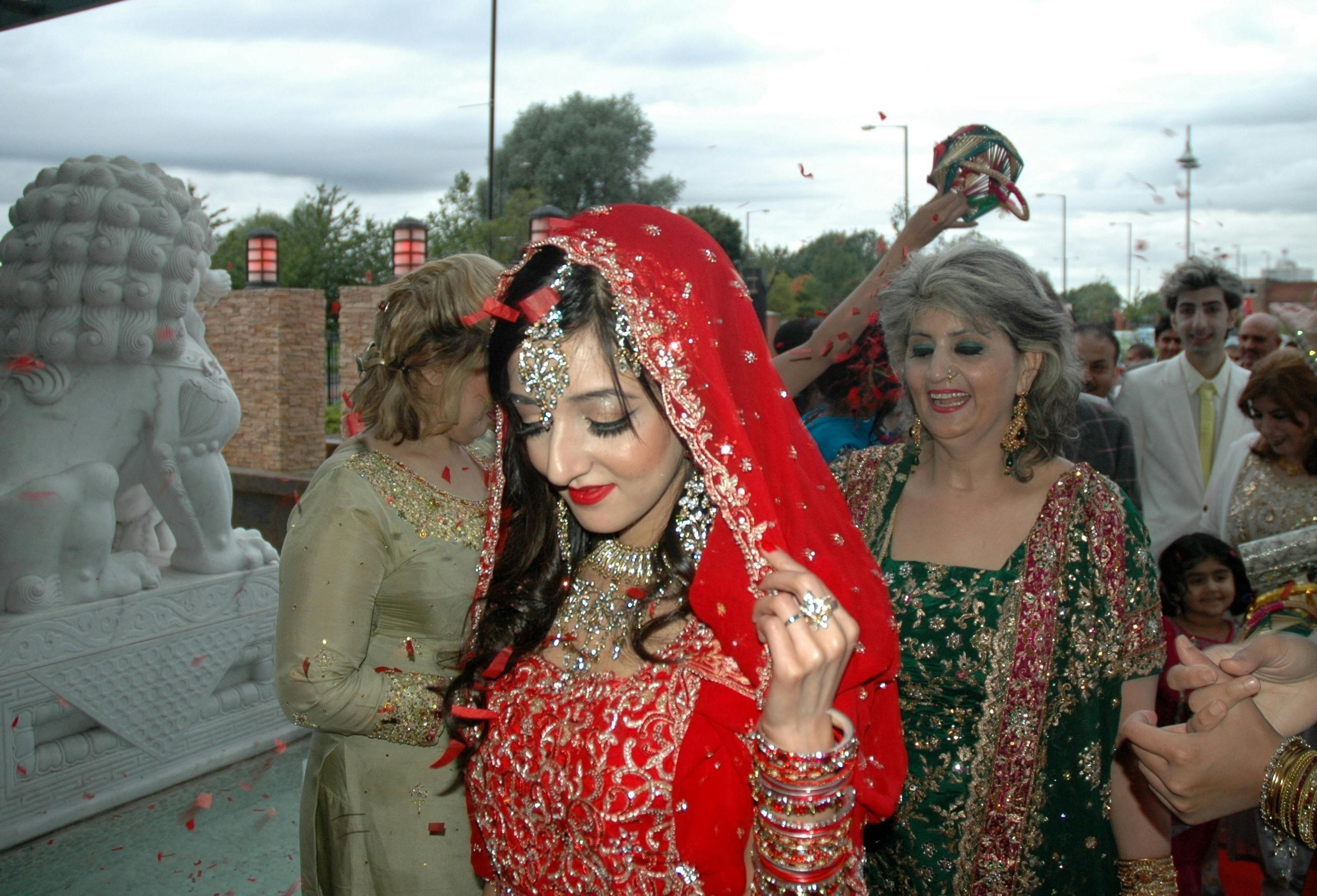 Vibrant wedding celebration at Abacus Gallery with a stunning bride in red attire.