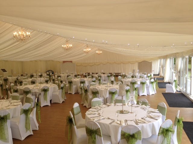 Elegant Pavilion at Quendon Hall, ideal for weddings with soft lighting and round tables.