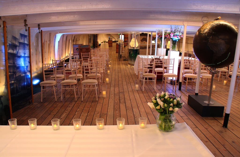 Elegant event space on Cutty Sark with floral centerpiece, perfect for celebrations.