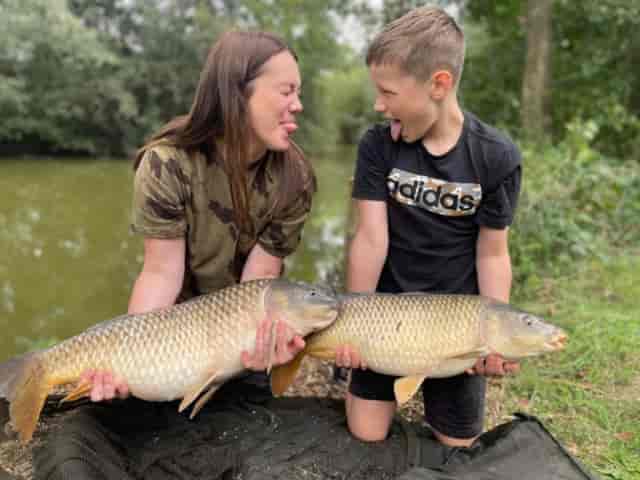 Children holding large fish at Exclusive Use in Fennes, perfect for outdoor team-building events.