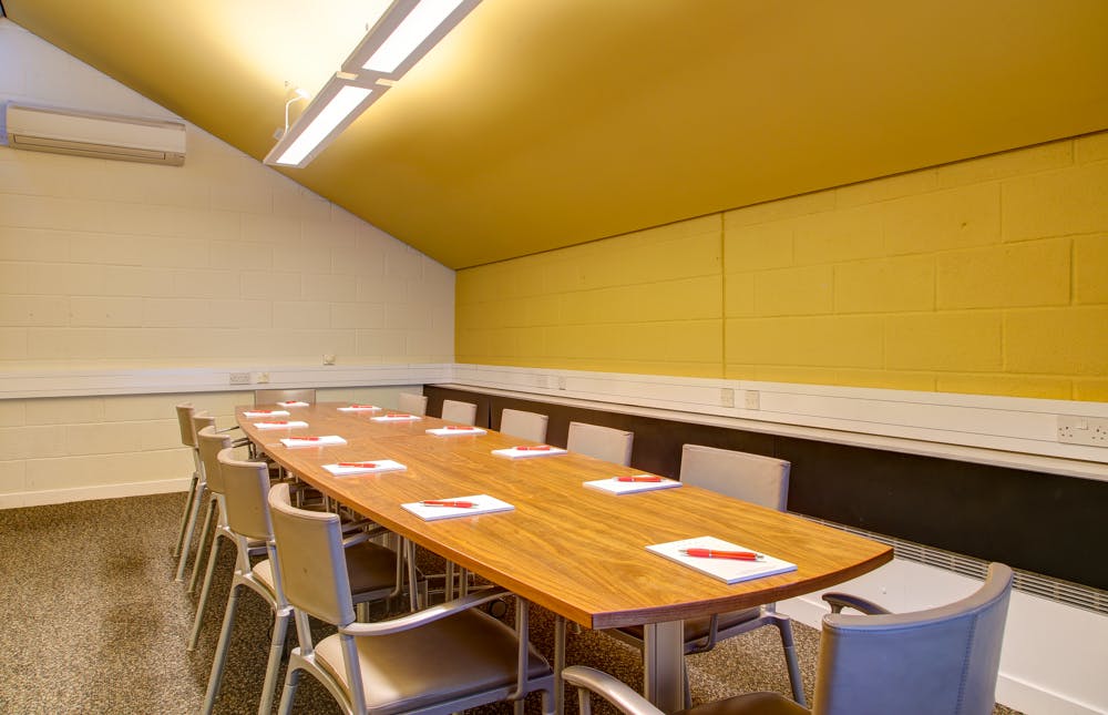 "Bright meeting room with wooden table at Cripplegate Rooms, ideal for workshops and discussions."