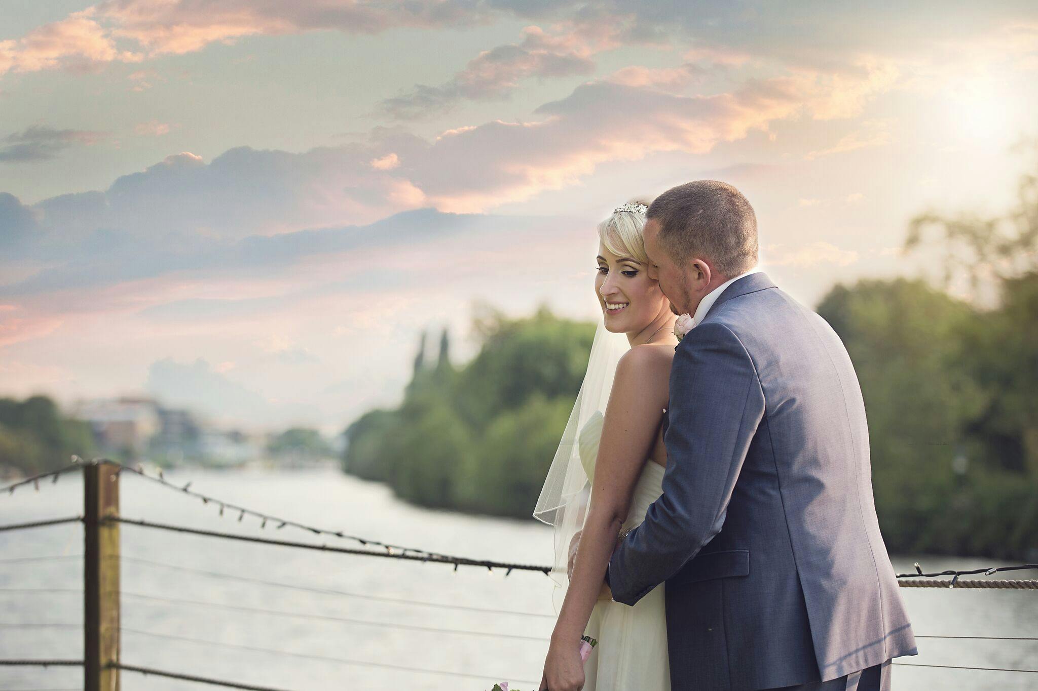 Romantic wedding couple by water at The Marquee, Ravens Ait Island.