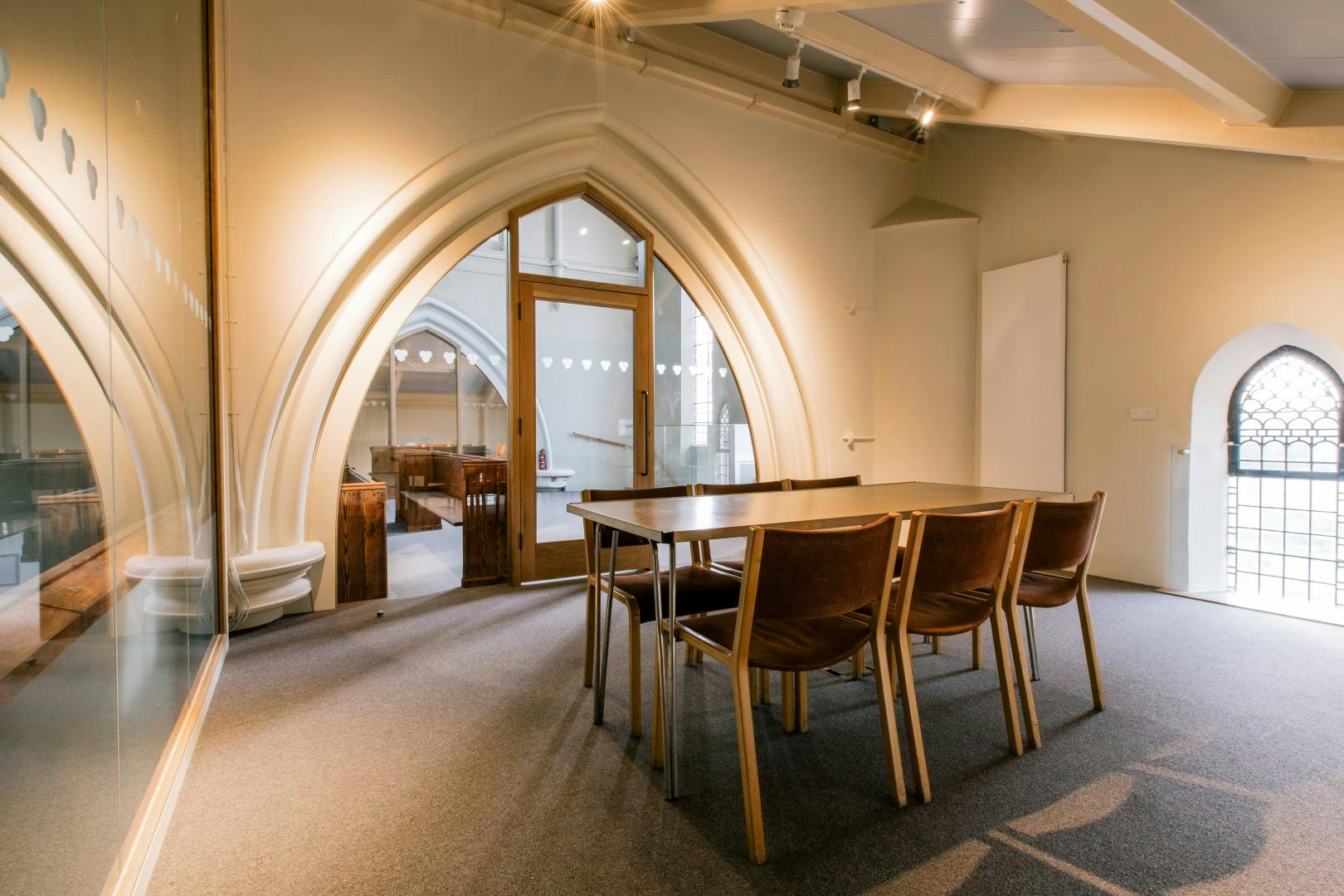 Modern meeting space in St John's Church with arched doorways, ideal for workshops.