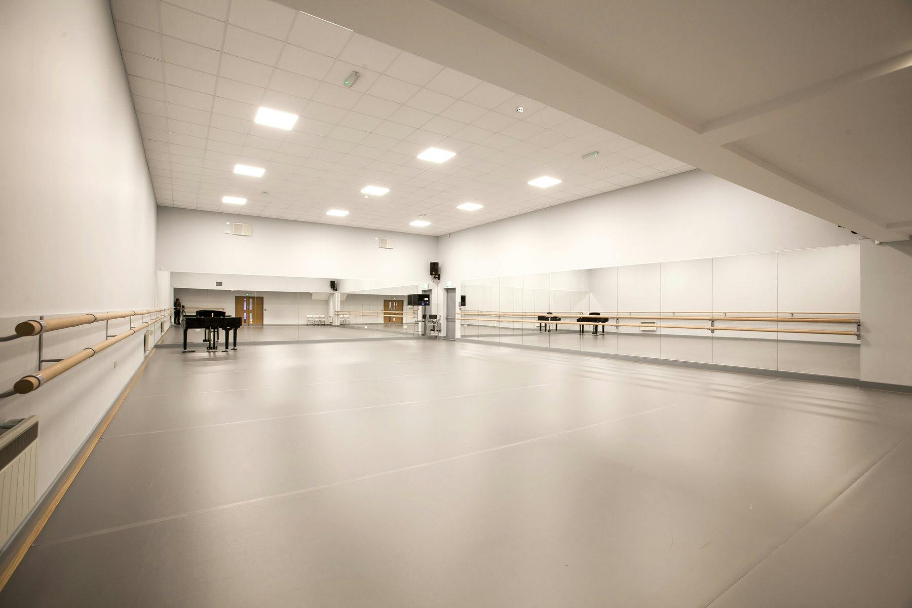 Spacious dance studio with mirrors, perfect for rehearsals and fitness classes.