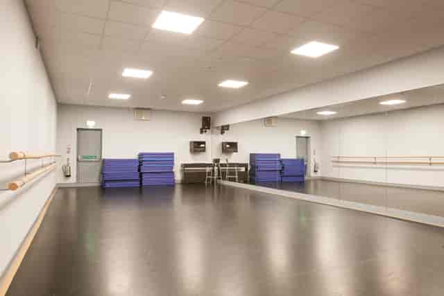 Versatile dance studio with mirrored wall for workshops and group sessions.