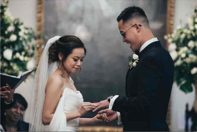 Couple exchanging vows in elegant Foundling Museum wedding ceremony with floral decor.