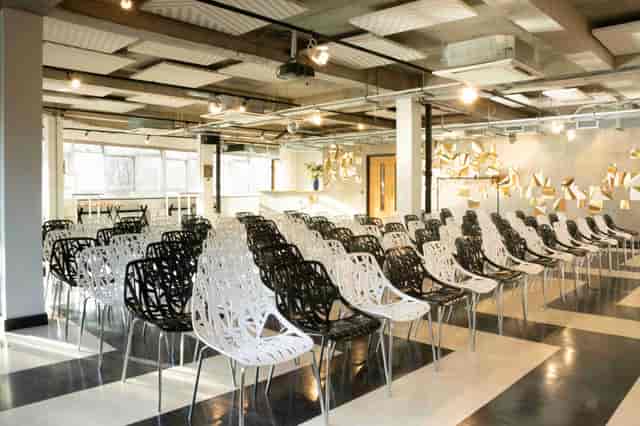 Modern event space with black and white chairs for corporate meetings and workshops.