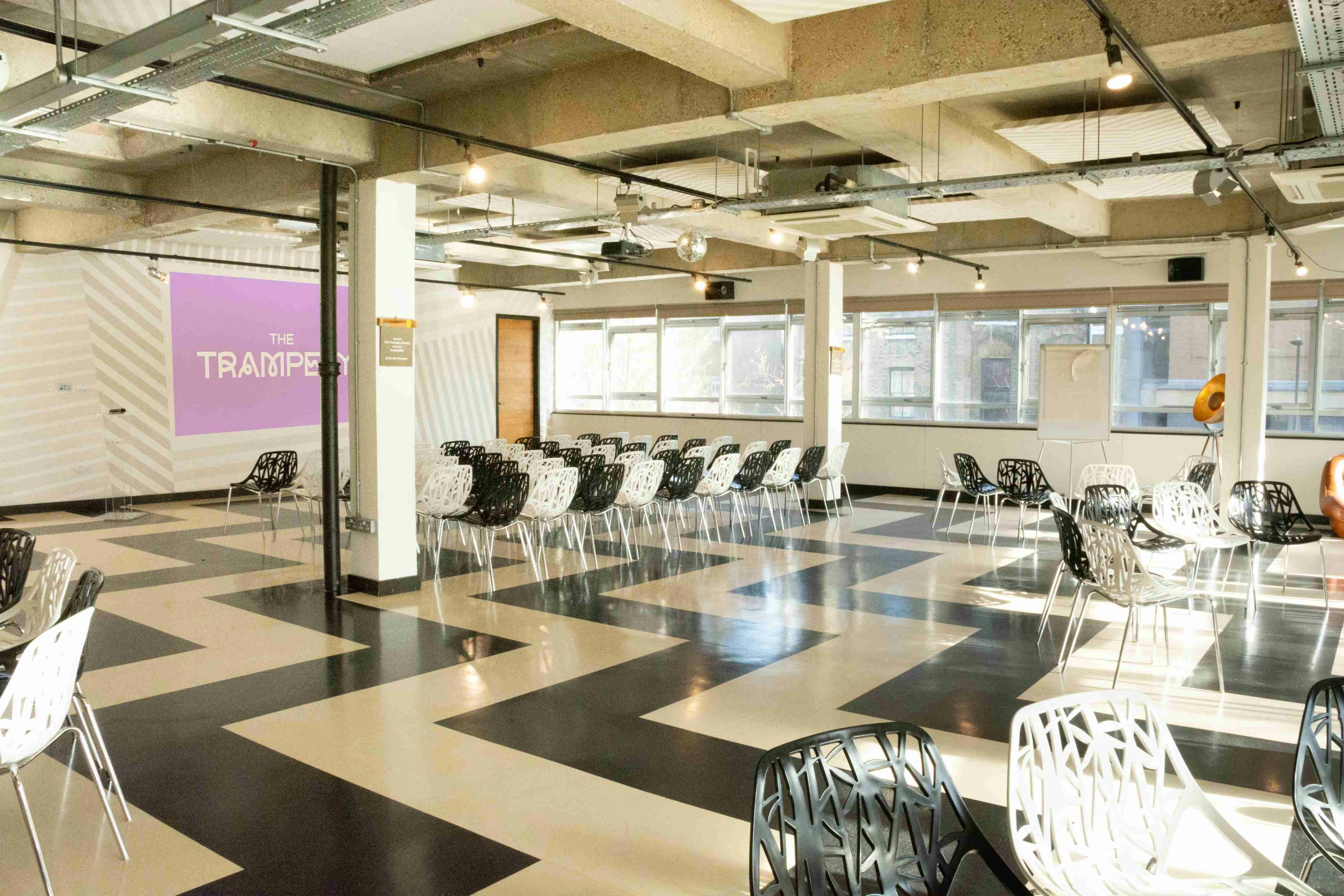Modern event space with black and white flooring, ideal for workshops and meetings.