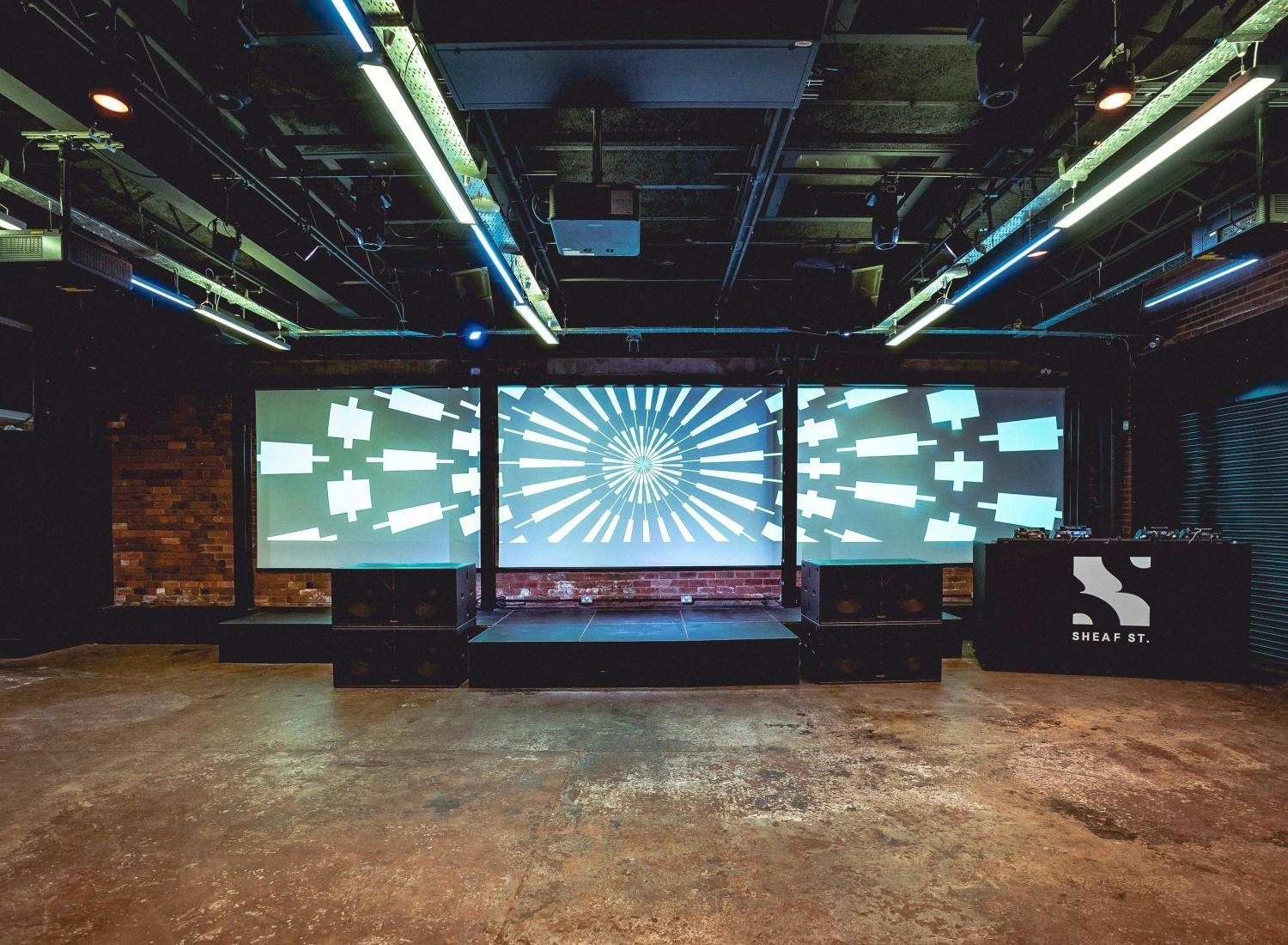Versatile event space with sleek stage and large screens for conferences and performances.
