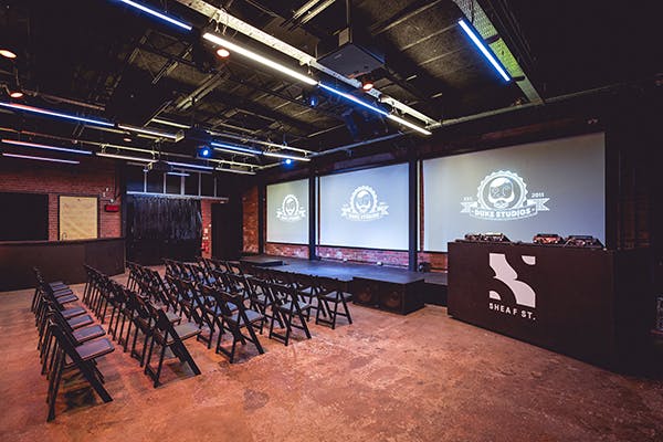 Versatile event space with projection screens for corporate meetings and creative gatherings.