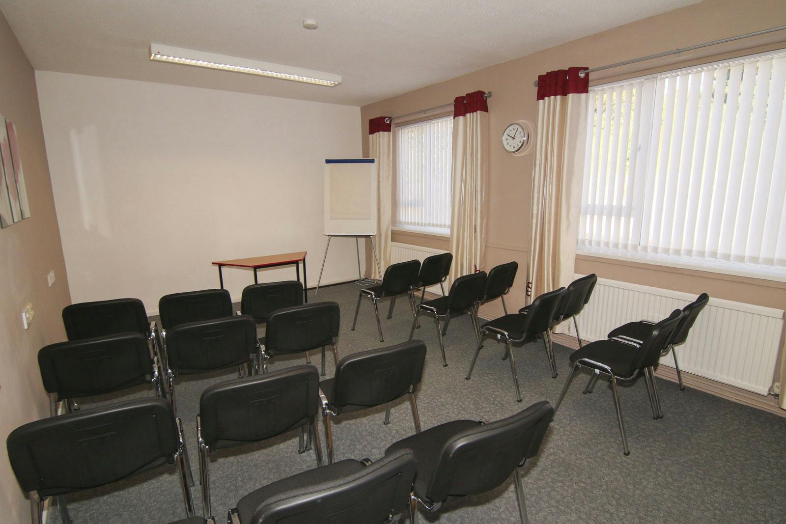 Briton Room in Ayton House: simple meeting space with black chairs for workshops.