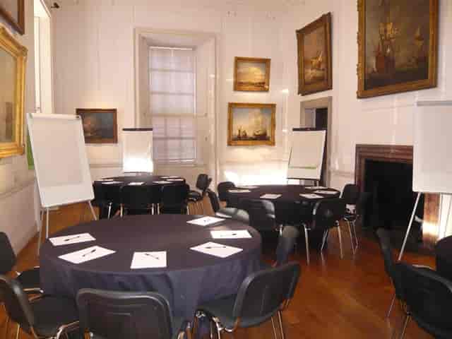 Elegant meeting space in The Queen's House with round tables for workshops and discussions.