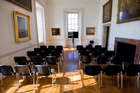 Orangery meeting room with black chairs, ideal for seminars and presentations.