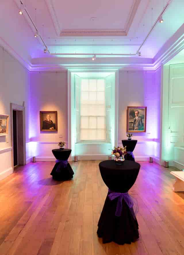 Elegant event space in The Queen's House with floral centerpieces for upscale gatherings.