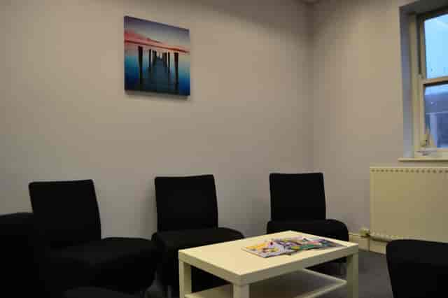 Minimalist Seaburn Suite meeting space with black chairs and white table for brainstorming.