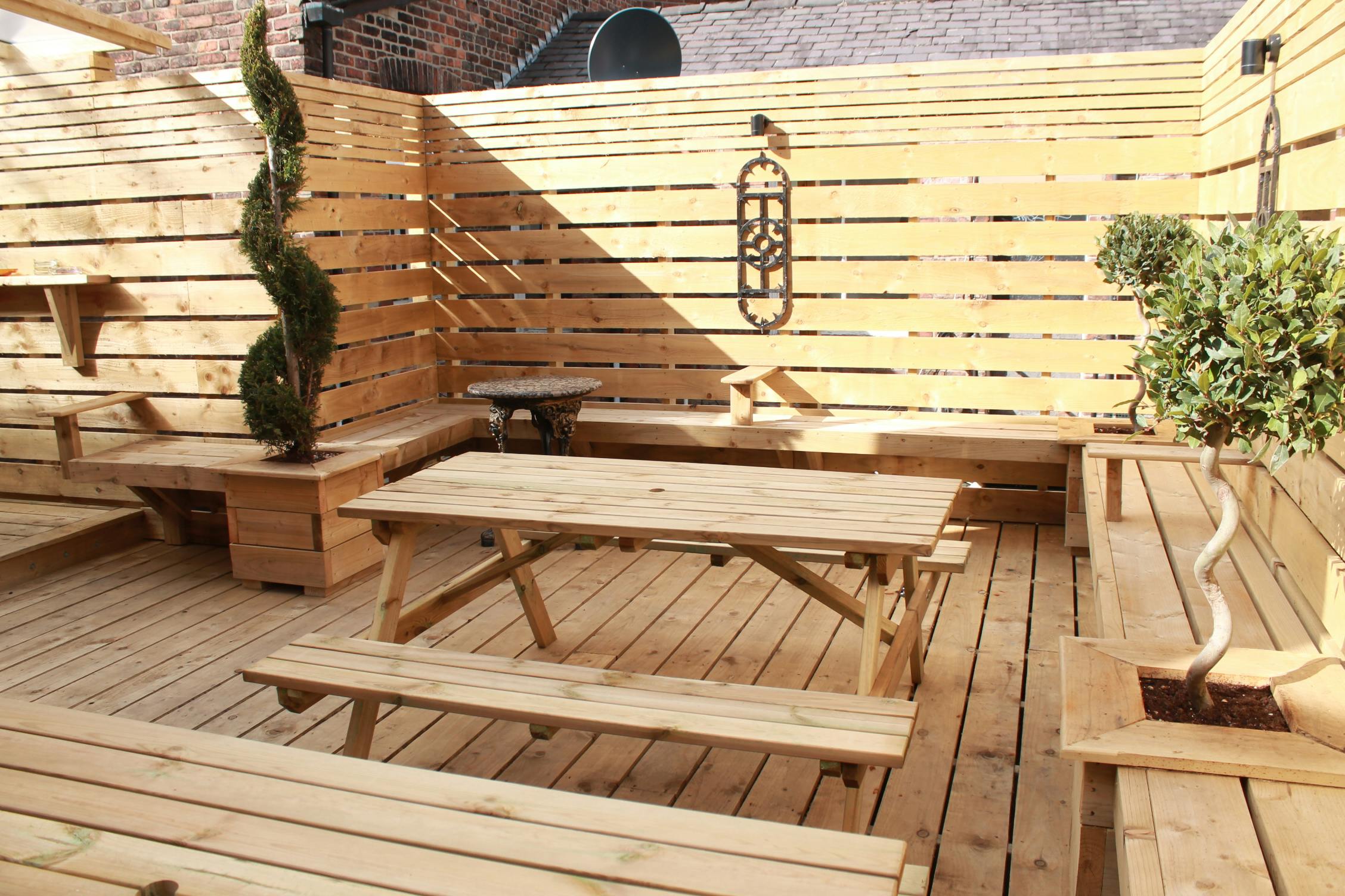 Roof terrace with wooden seating, ideal for casual meetings and networking events.