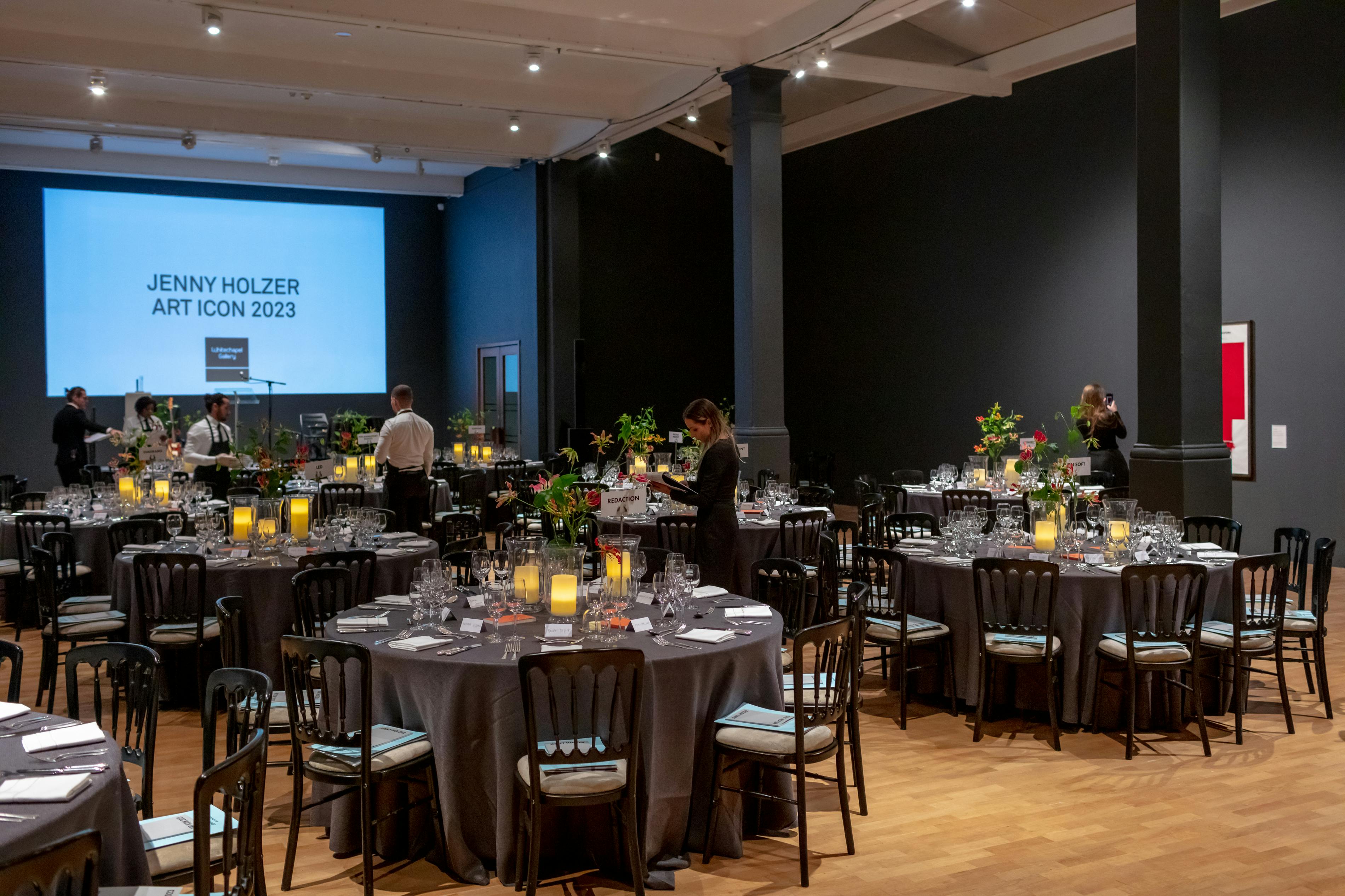 Elegant gala dinner setup in Whitechapel Gallery with floral centerpieces and warm lighting.