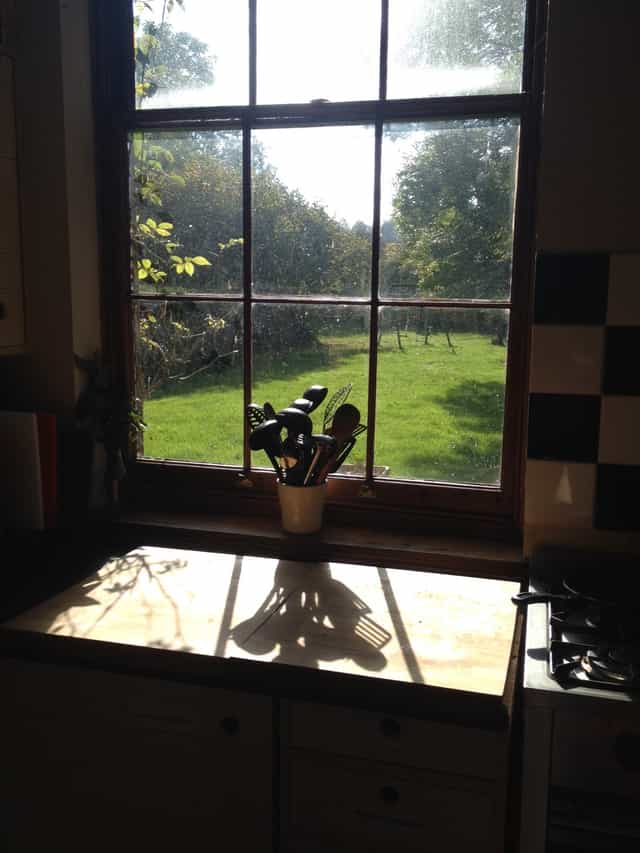 Serene farmhouse kitchen with sunlight, perfect for culinary workshops and gatherings.