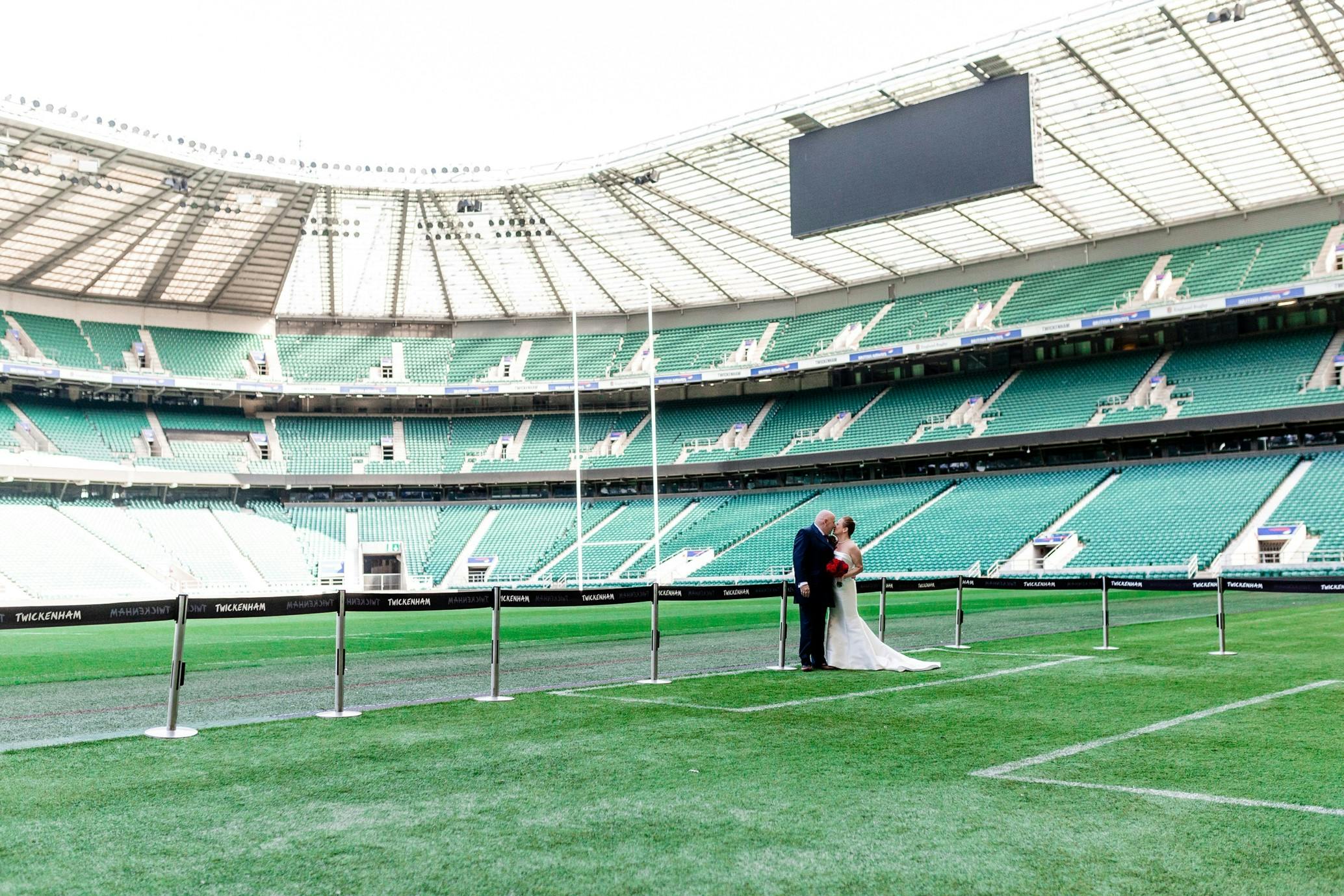 Couple on pitch at Allianz Stadium, unique wedding venue for unforgettable events.