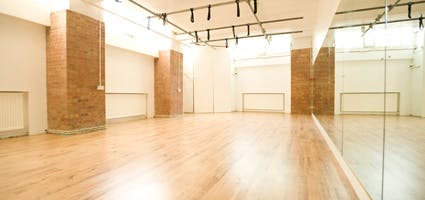 Versatile event space with polished wooden floors at London Dance Academy for workshops and yoga.