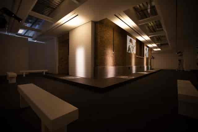 Minimalist gallery with industrial brick and accent lighting for product launches or art exhibits.
