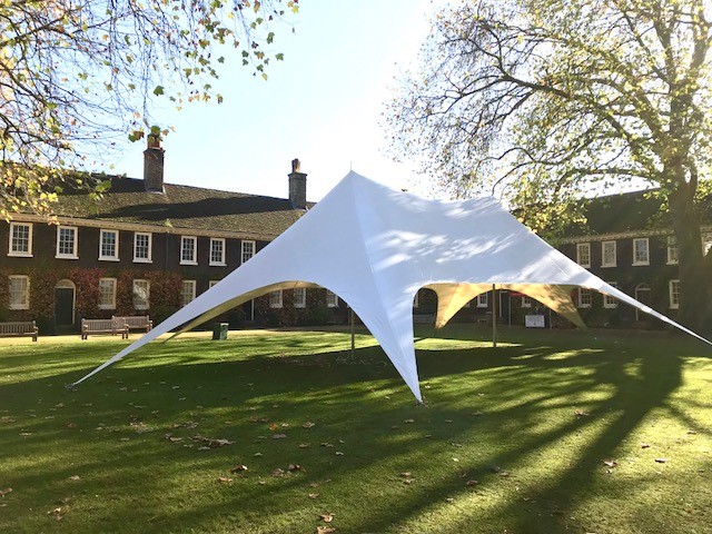 Stylish tensioned fabric tent on lush lawn for outdoor weddings and events. - Banner