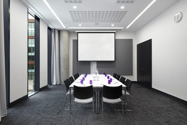 Modern meeting room at INNSIDE Manchester with sleek design, ideal for workshops and presentations.