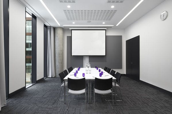 Modern meeting room at INNSIDE Manchester with sleek design, ideal for workshops and presentations.