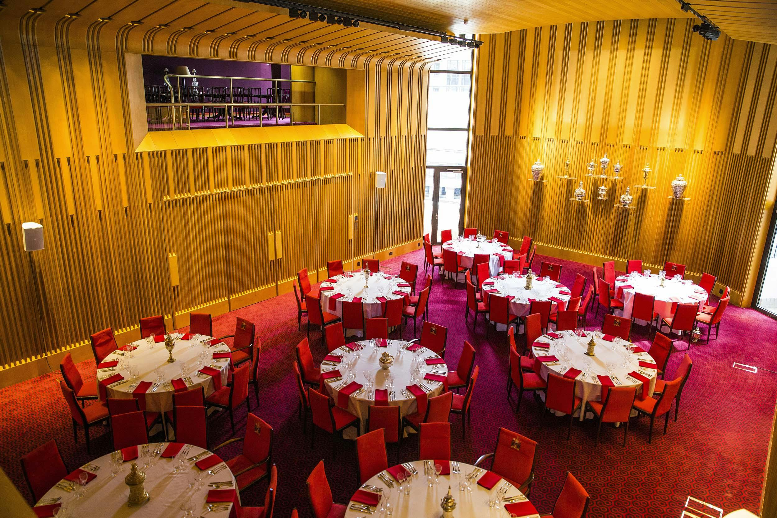 Elegant Main Hall with round tables and red chairs for corporate events and banquets.