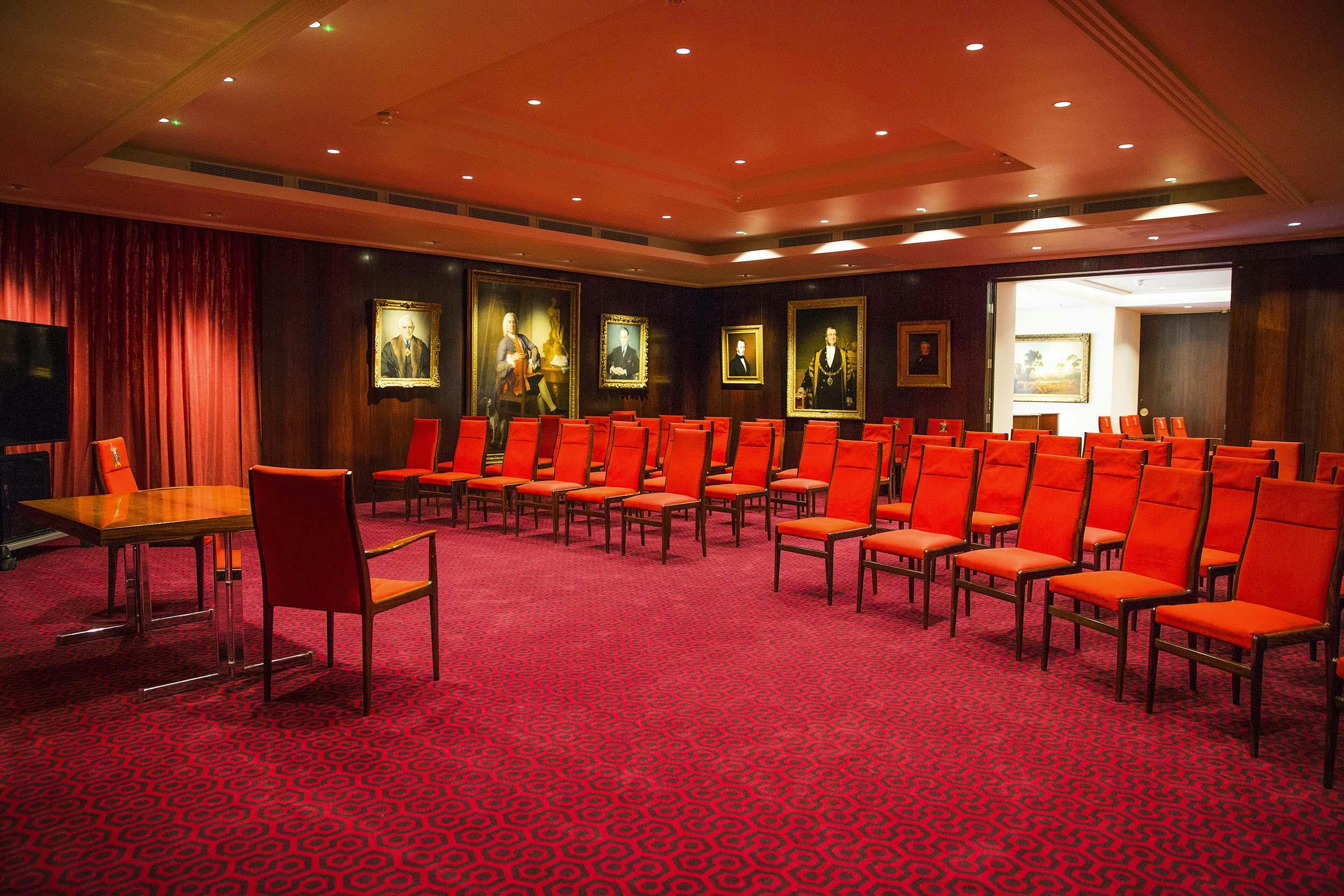 Elegant meeting room in Salters' Hall with red chairs, perfect for workshops and presentations.