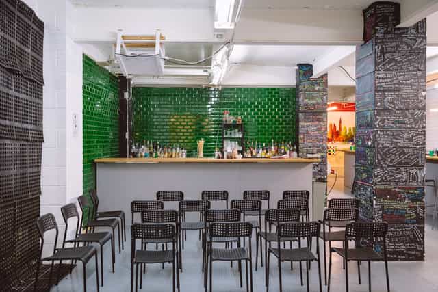 Main Room at London Bartender School with green tiled bar for events and workshops.