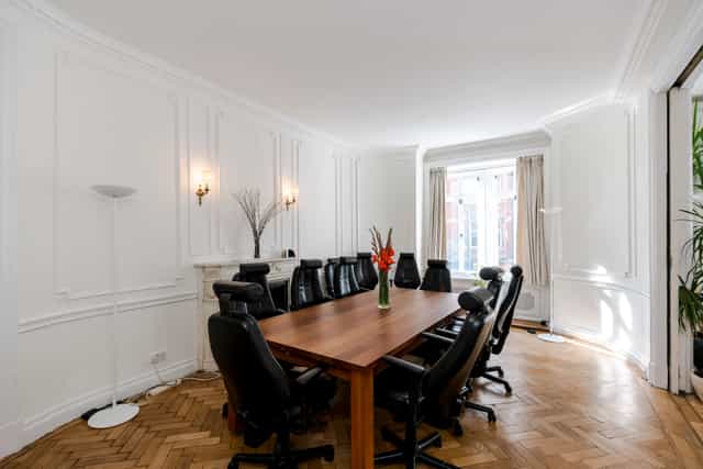 Boutique boardroom with wooden table, ideal for professional meetings and brainstorming sessions.