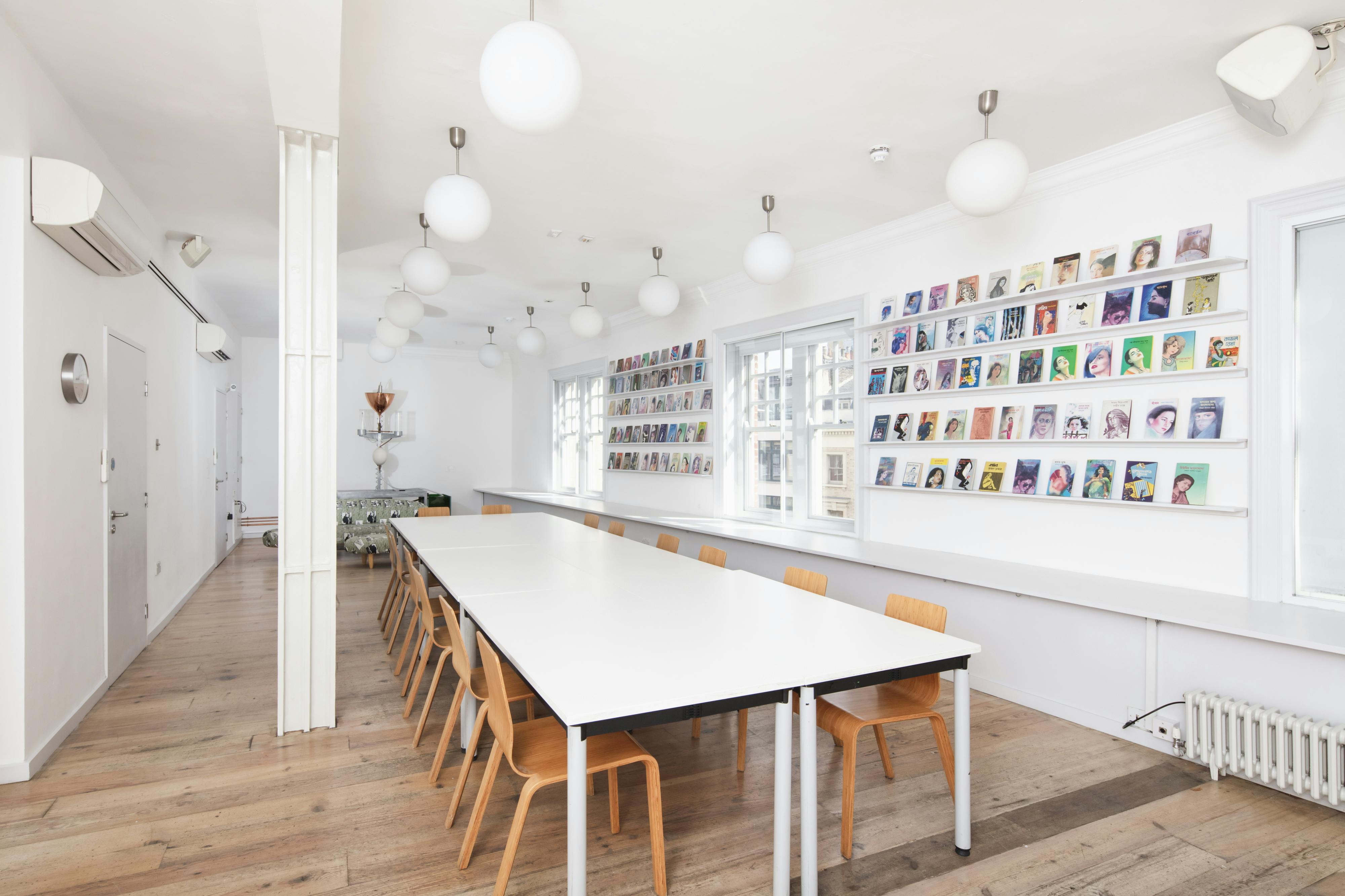 Modern meeting space with white table and wooden chairs at Whitechapel Gallery.