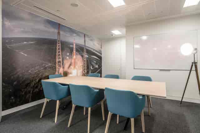 Buzz Aldrin in a modern boardroom with mural wall for corporate workshops and team meetings.