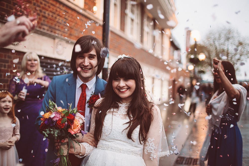 Joyful wedding celebration in The Balcony Room, confetti-filled exit with loved ones.